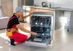 Teknik servis çalışanı bulaşık makinesi tamiri yaparken; cihazın içi ve servis ekipmanları görünmekte